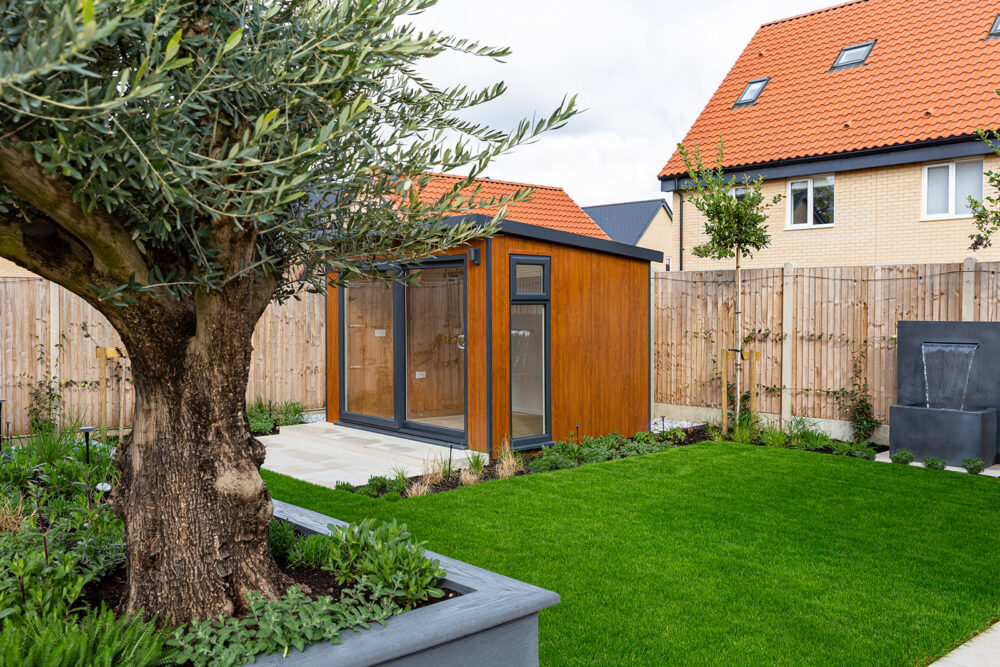 Full garden view showing outdoor living space, garden room, and bespoke planters